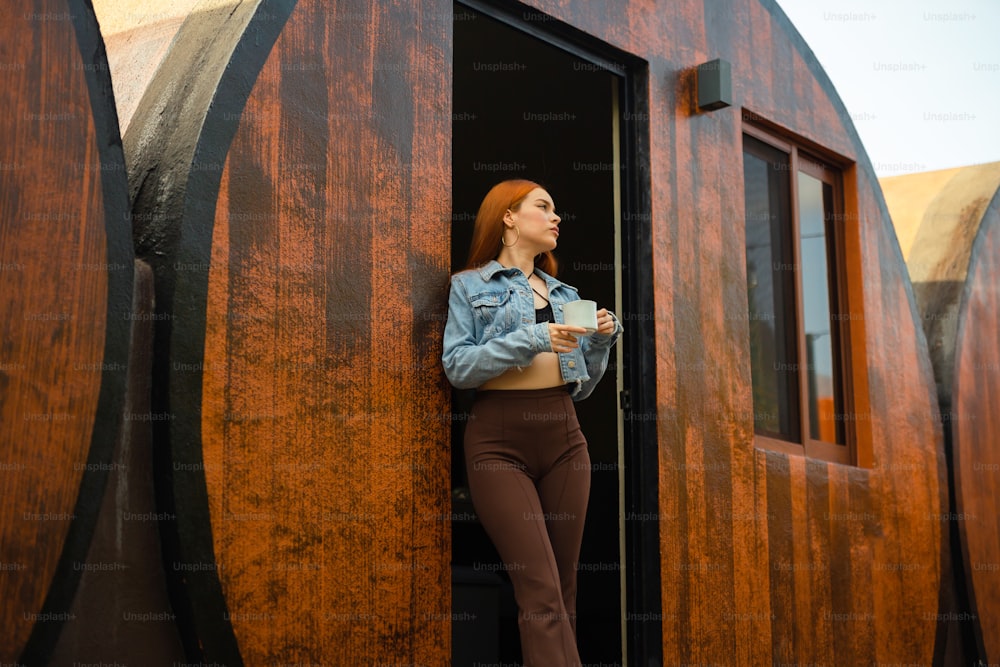 a woman standing in a doorway with a cup of coffee
