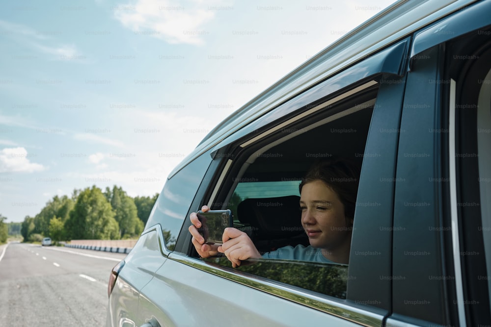 a woman taking a picture of herself in a car