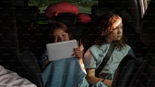 two little girls sitting in the back of a car