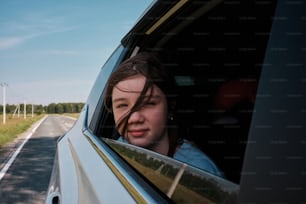 a woman looking out the window of a car