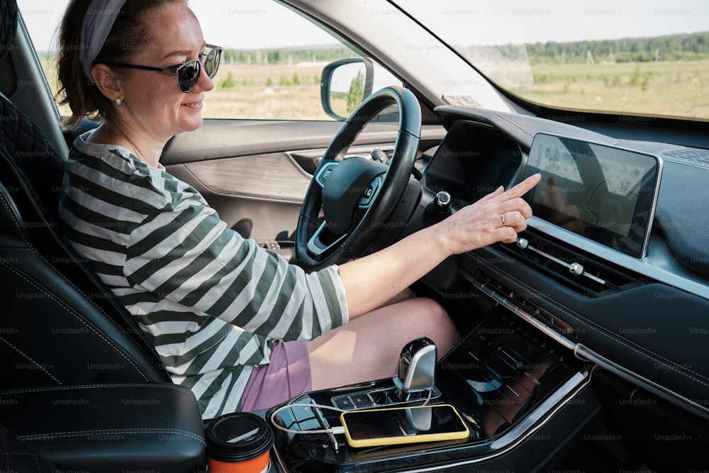 a woman driving a car on a rural road