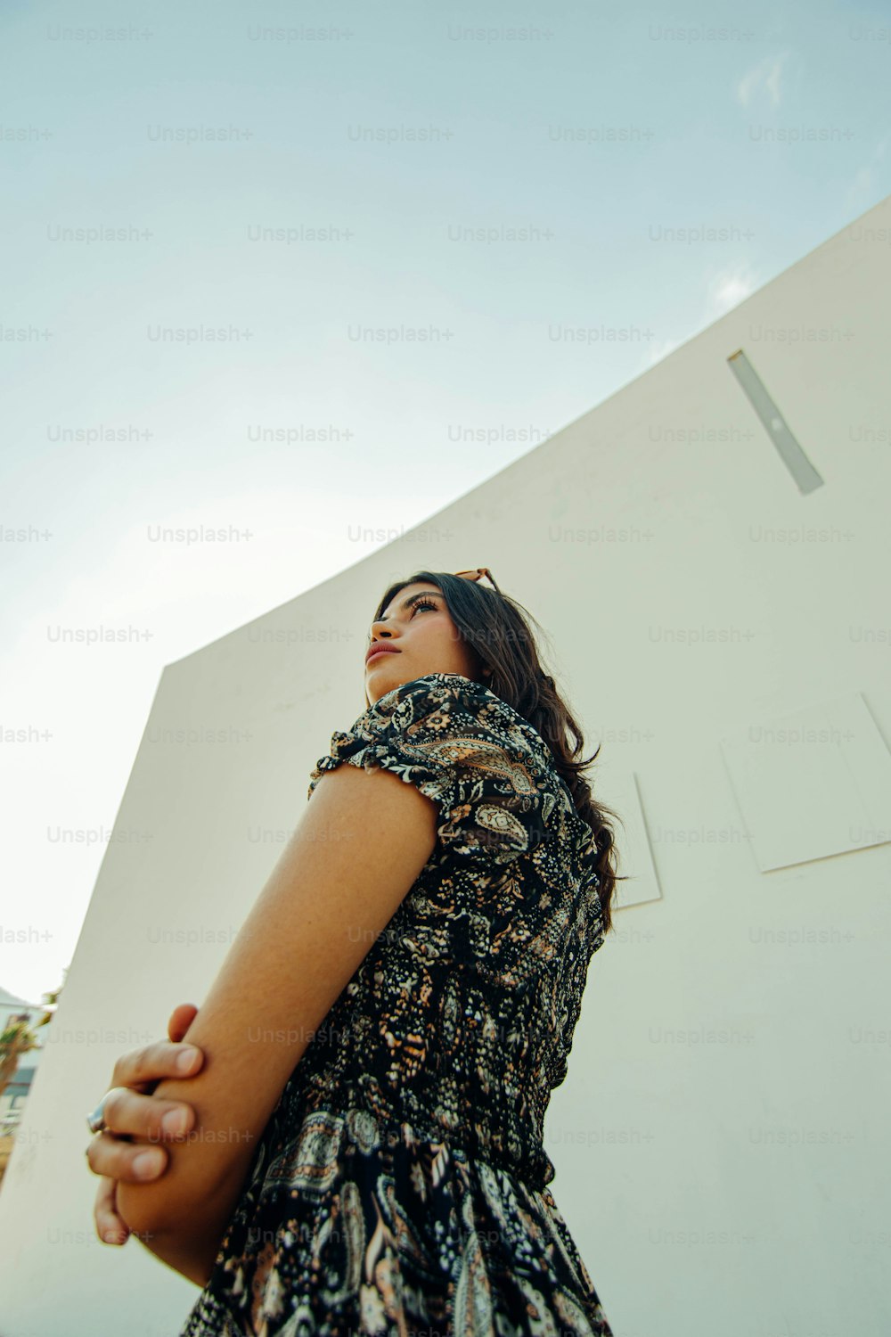 Une femme debout devant un bâtiment blanc