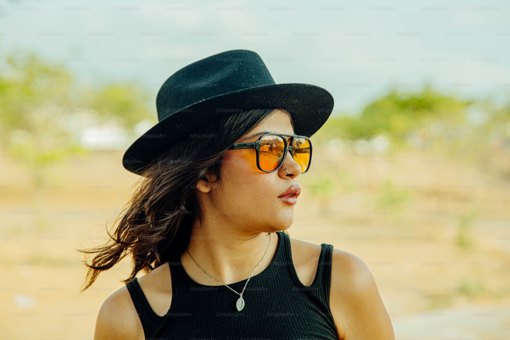 Una mujer con sombrero negro y gafas de sol