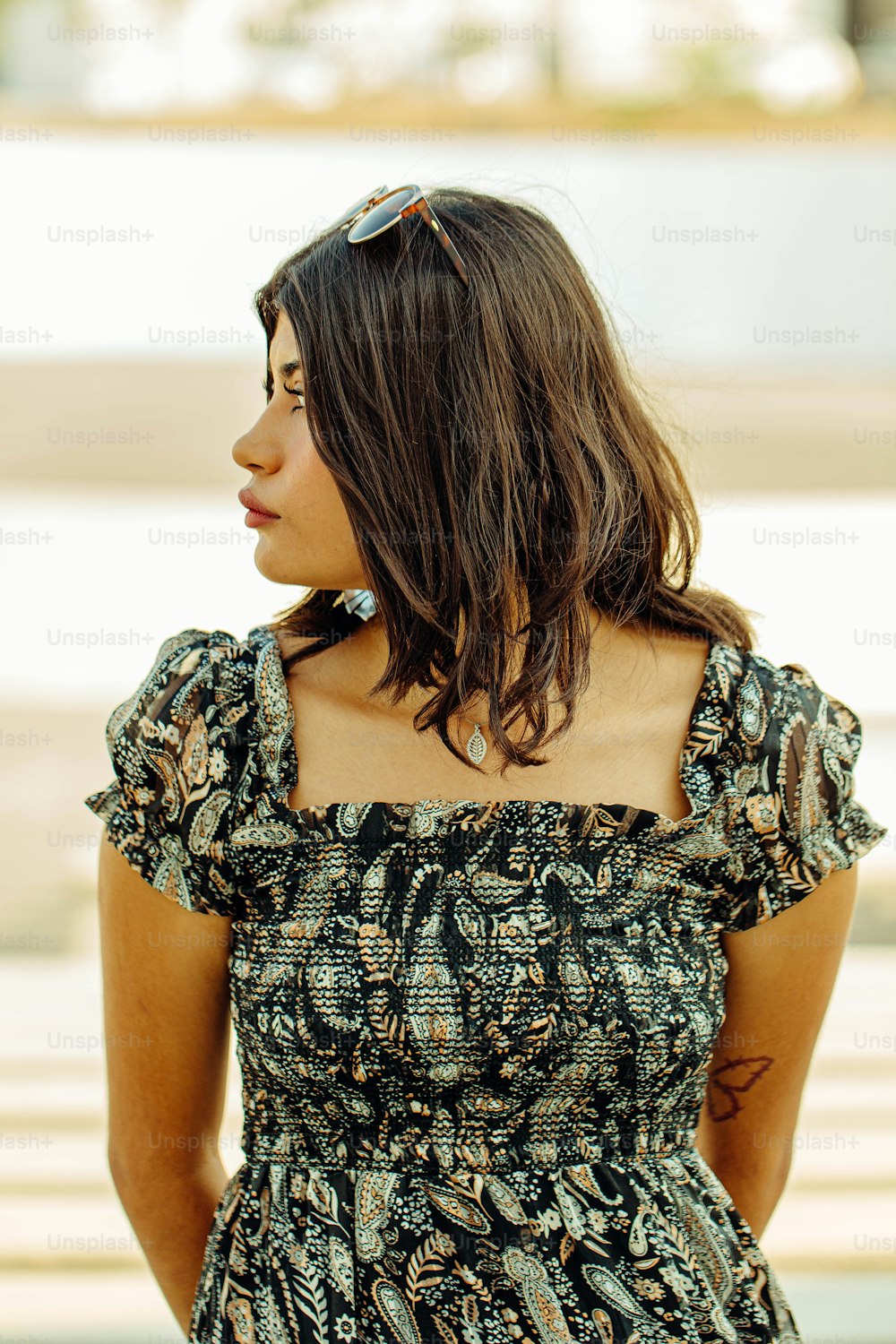 uma mulher em um vestido olhando para longe da câmera