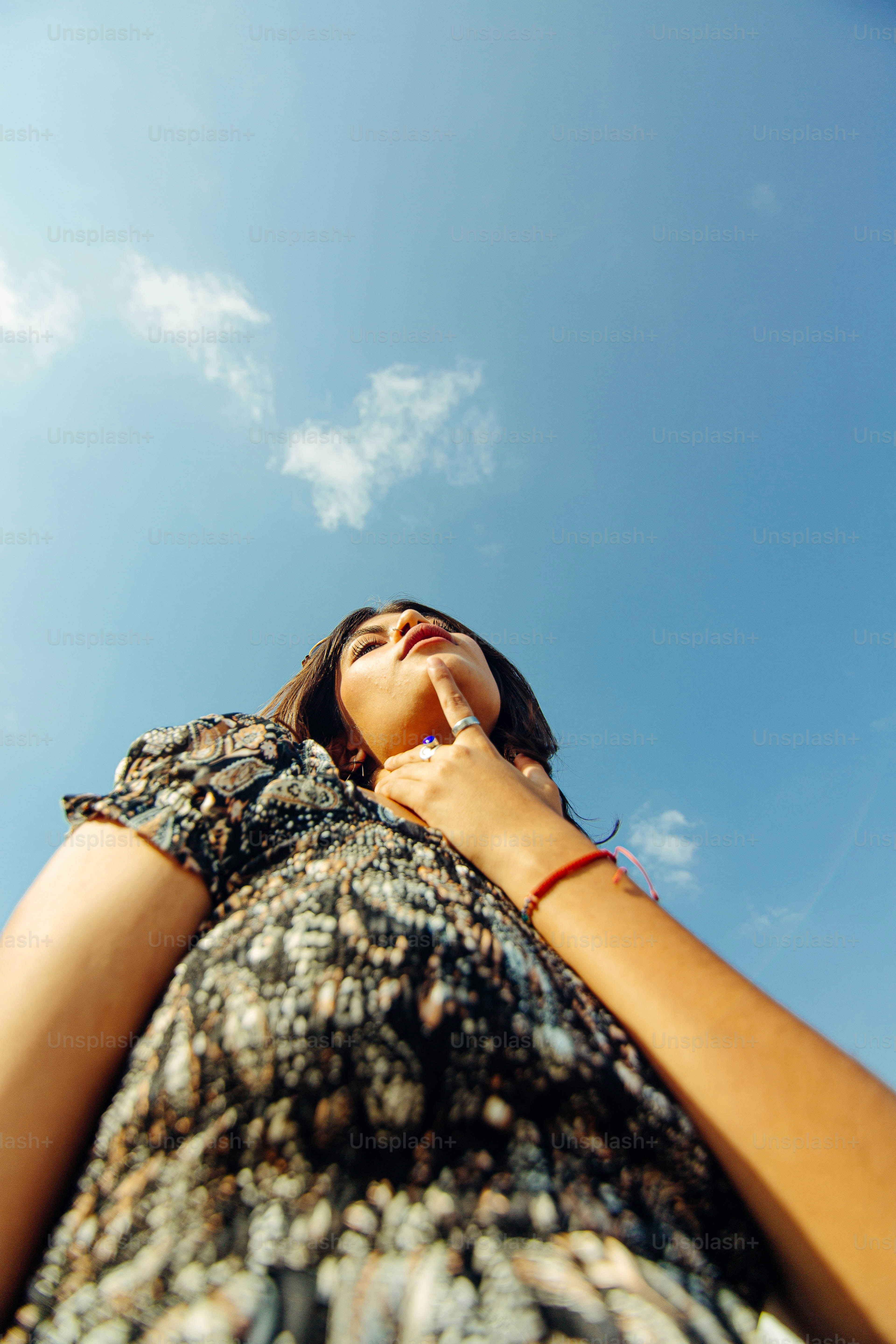 A woman standing in front of a blue sky photo – Portrait Image on Unsplash