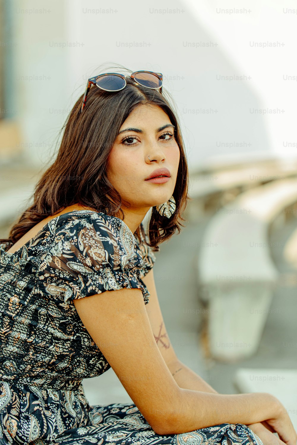 a woman wearing sunglasses sitting on a bench