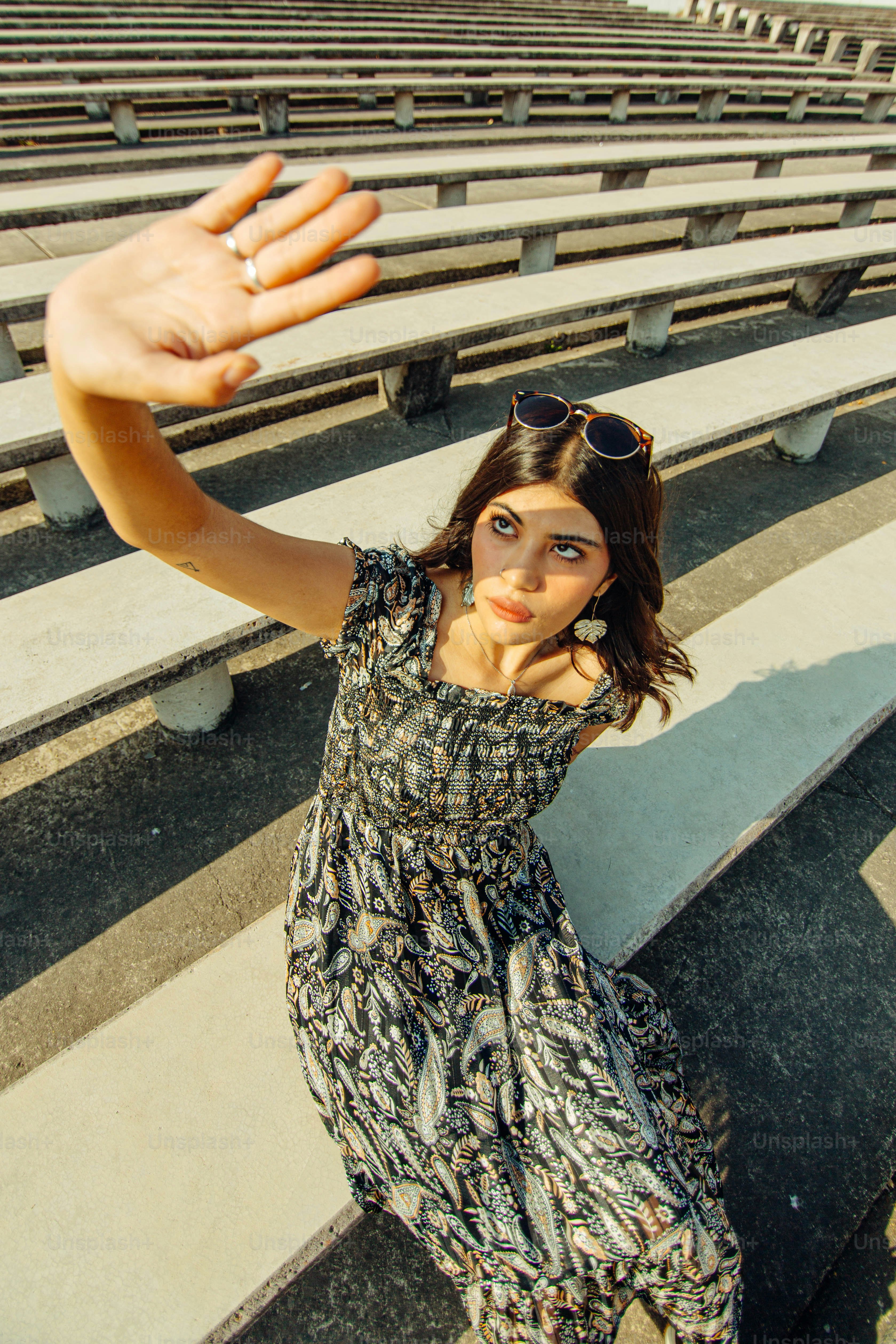 a woman standing in front of a row of bleachers