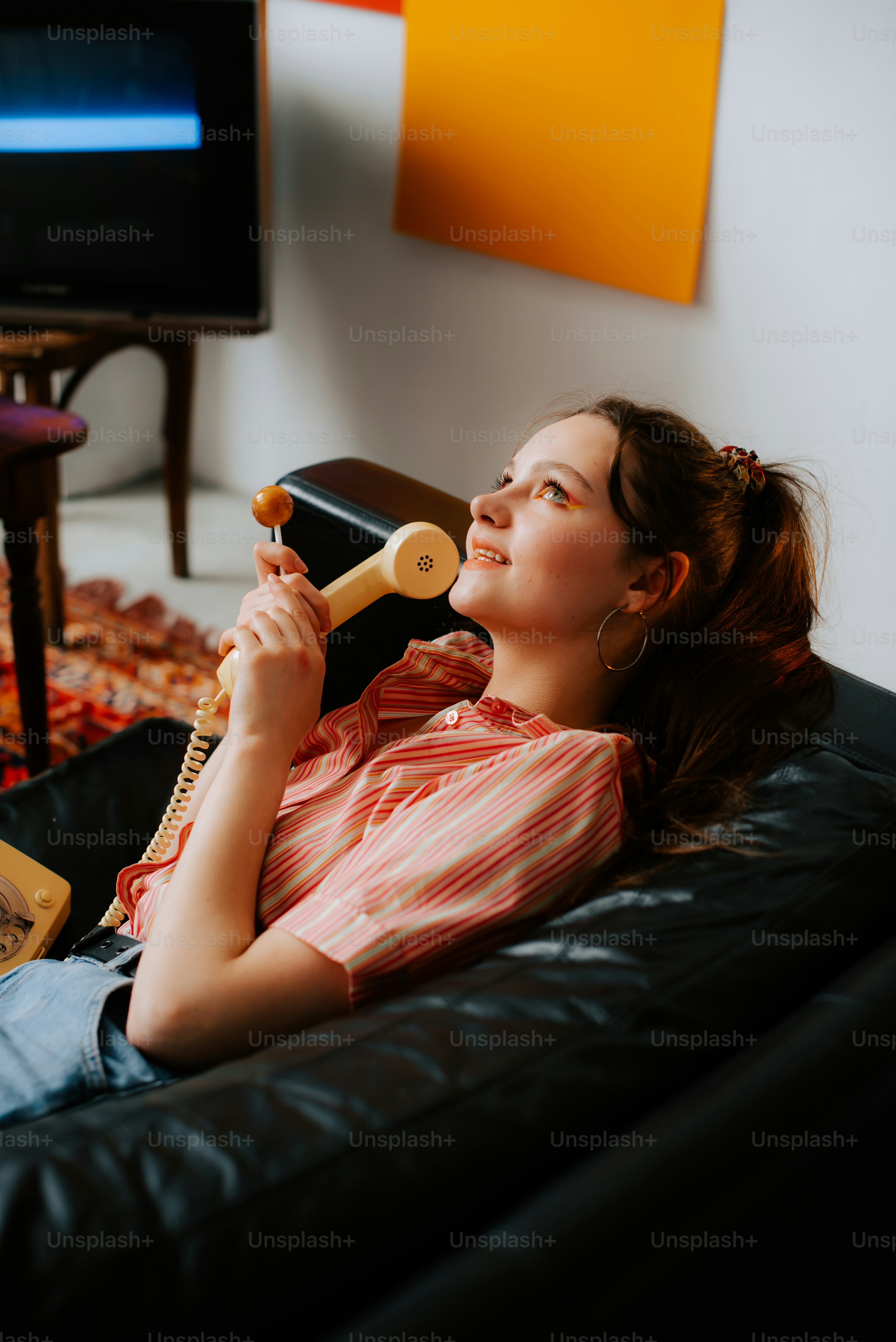 a woman sitting on a couch talking on a phone
