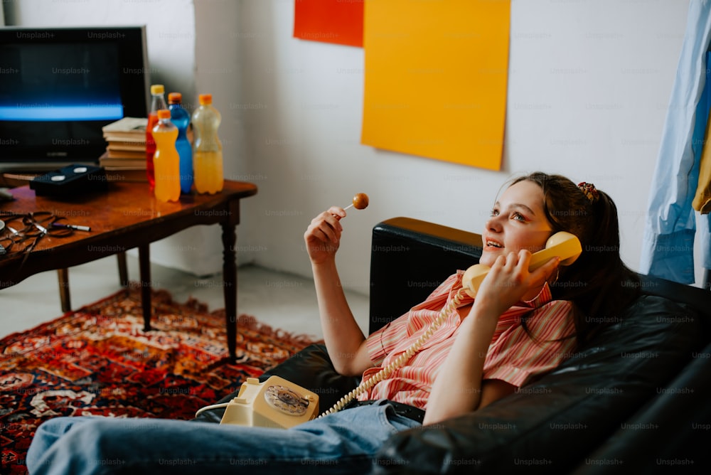 a woman sitting on a couch talking on a phone