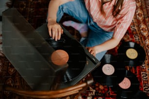 a woman sitting on the floor next to a record player