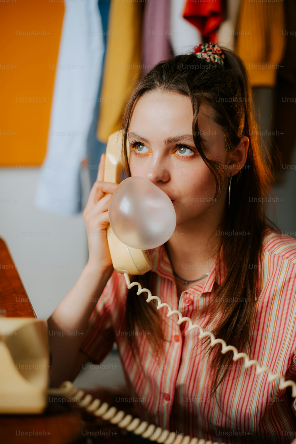 a woman talking on a phone while holding a bubble