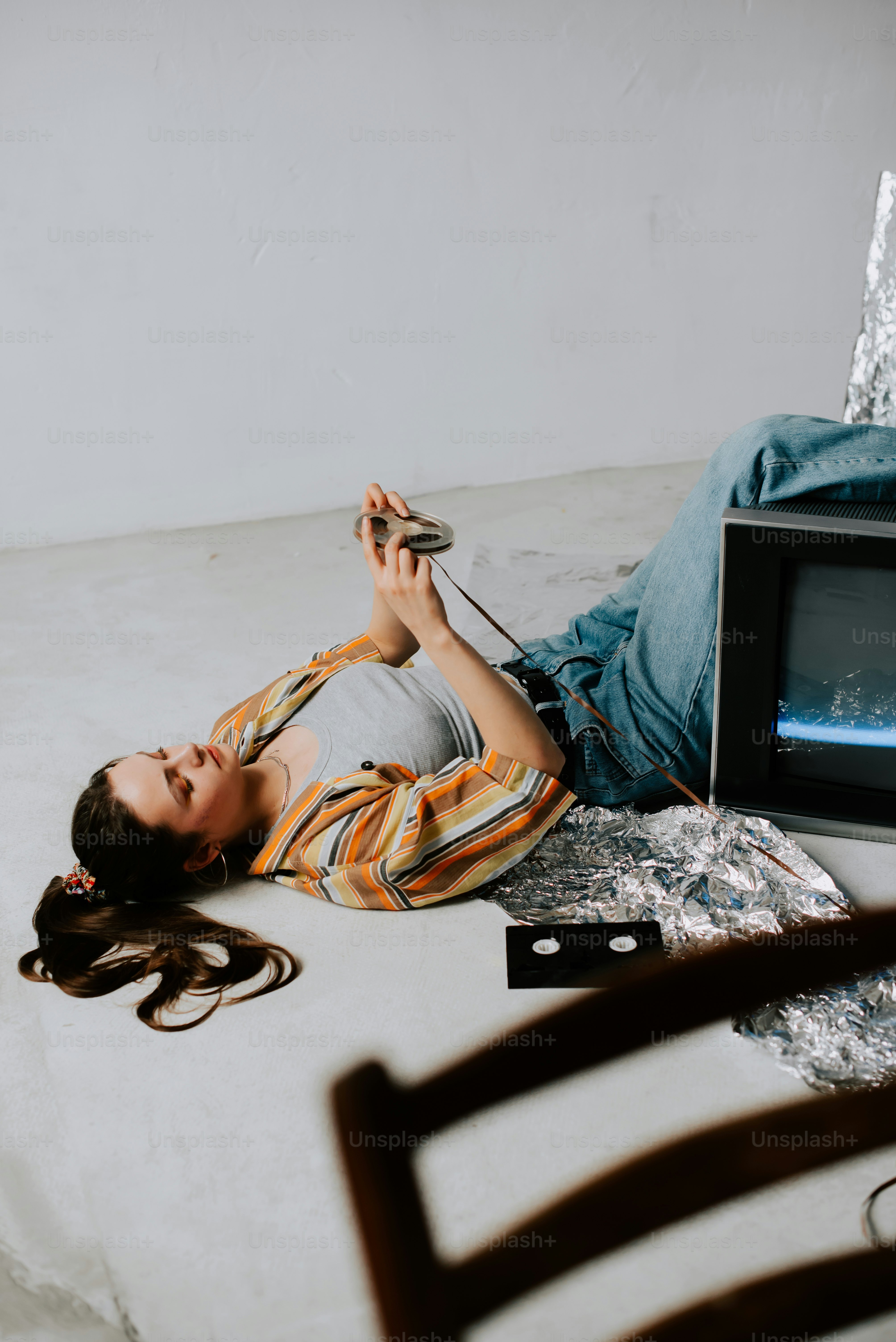 a woman laying on the ground next to a tv