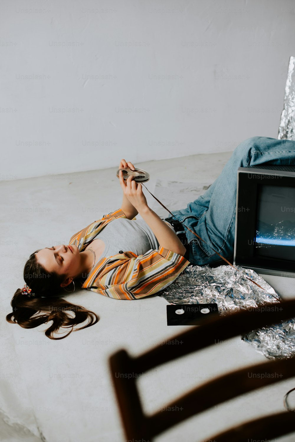 a woman laying on the ground next to a tv