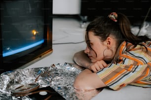 a woman laying on the ground next to a tv