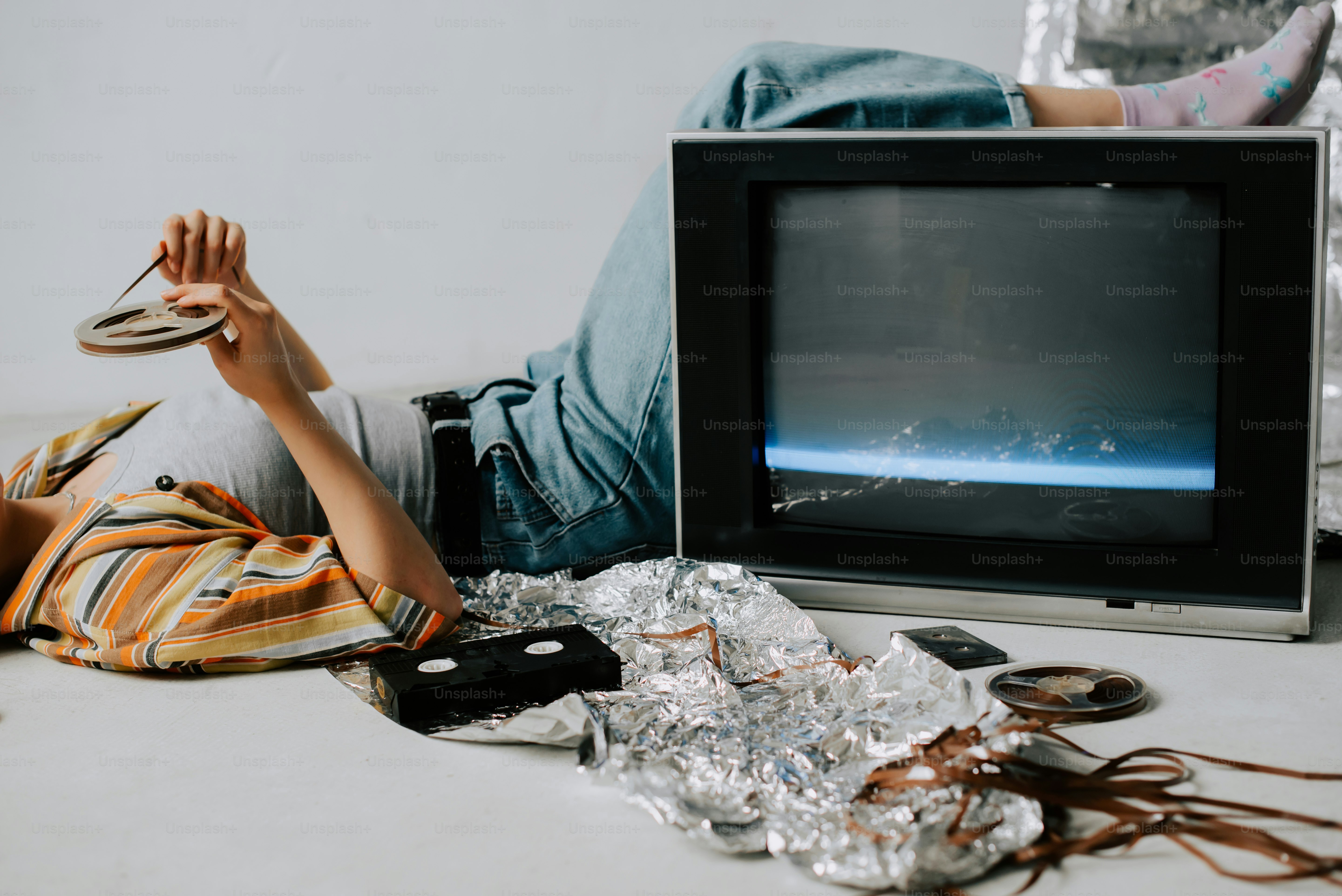 a person laying on the ground next to a television