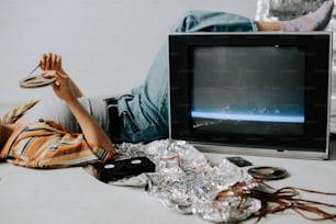 a person laying on the ground next to a television