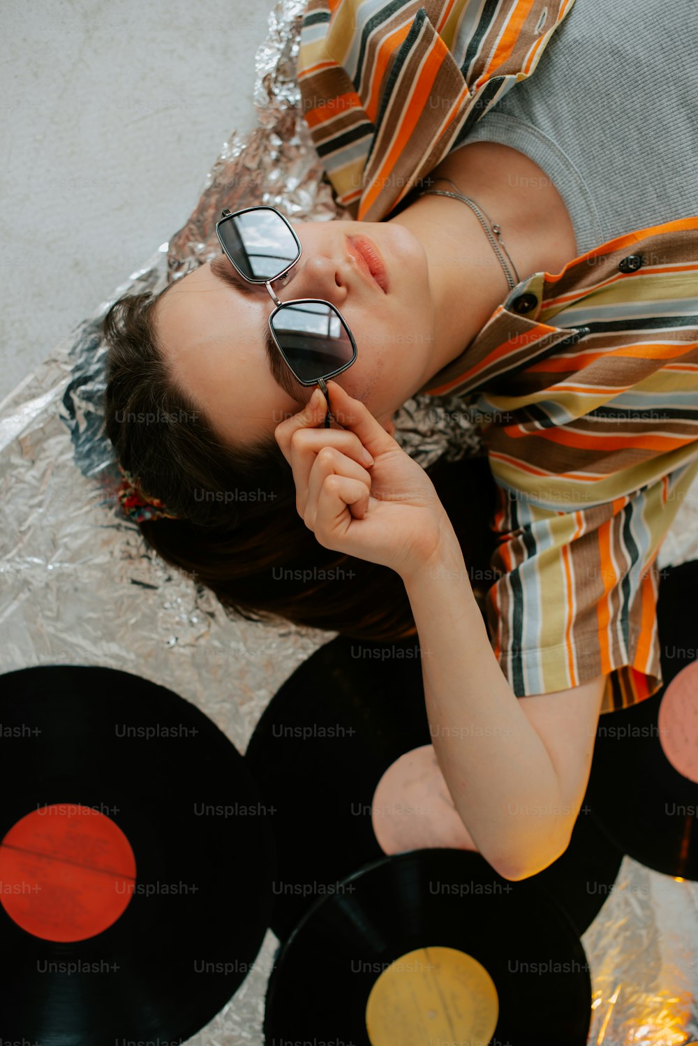 a woman laying on top of a pile of records