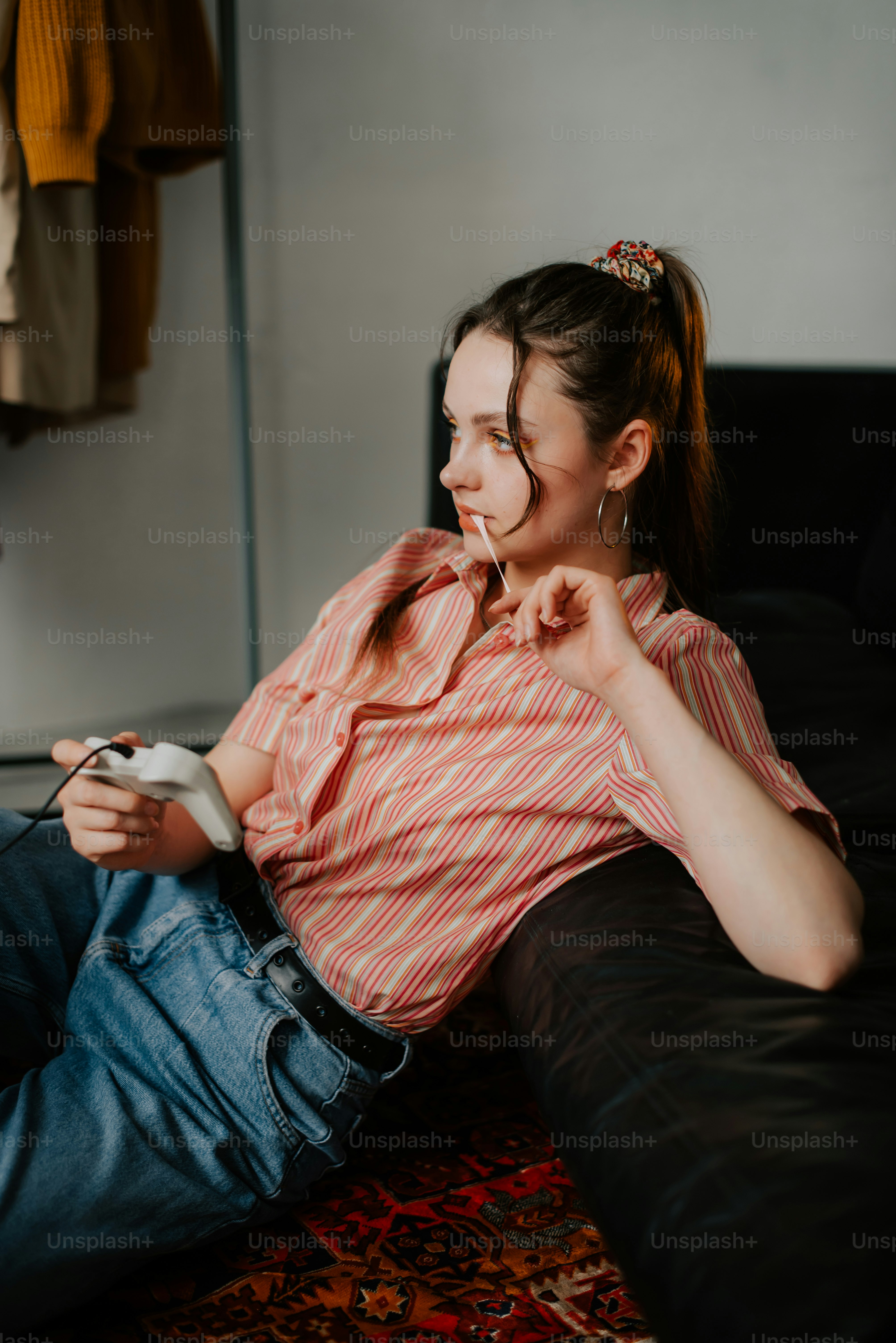 a woman sitting on a couch holding a remote control