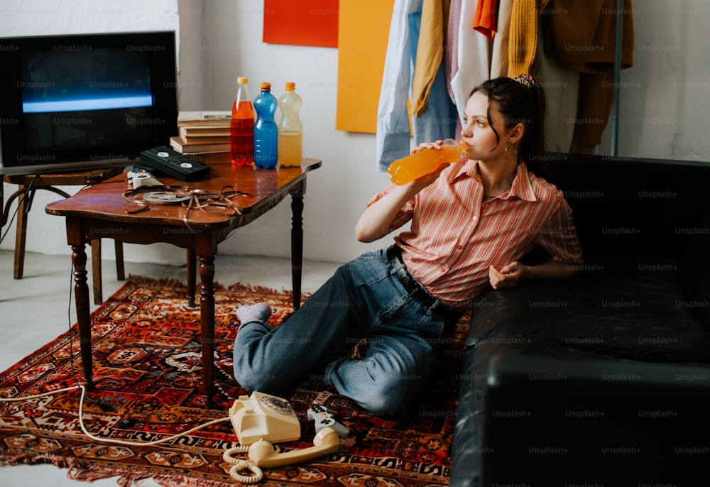 a woman sitting on the floor in front of a tv