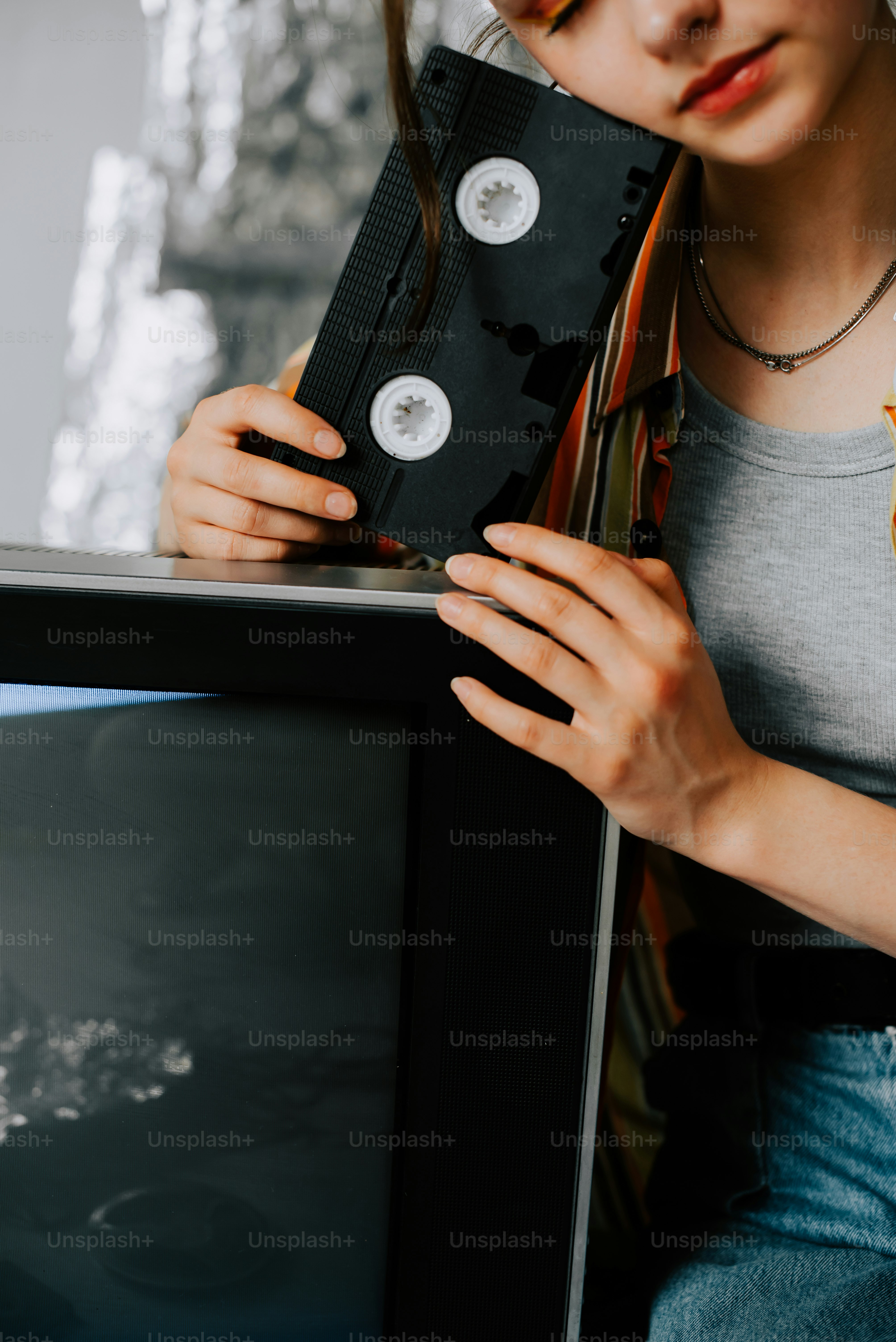a woman holding a tape recorder in front of a tv
