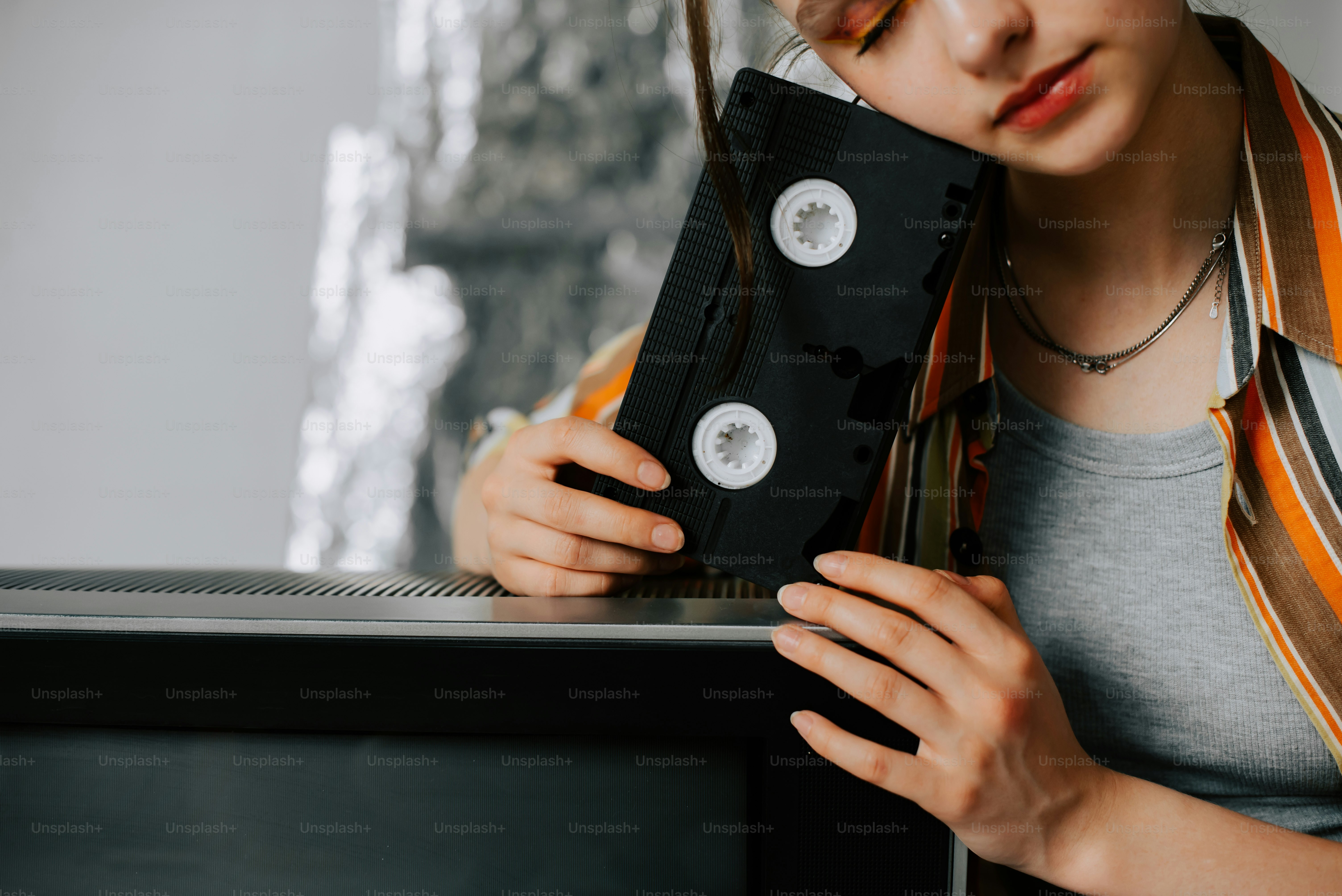 a woman holding a black object in front of her face