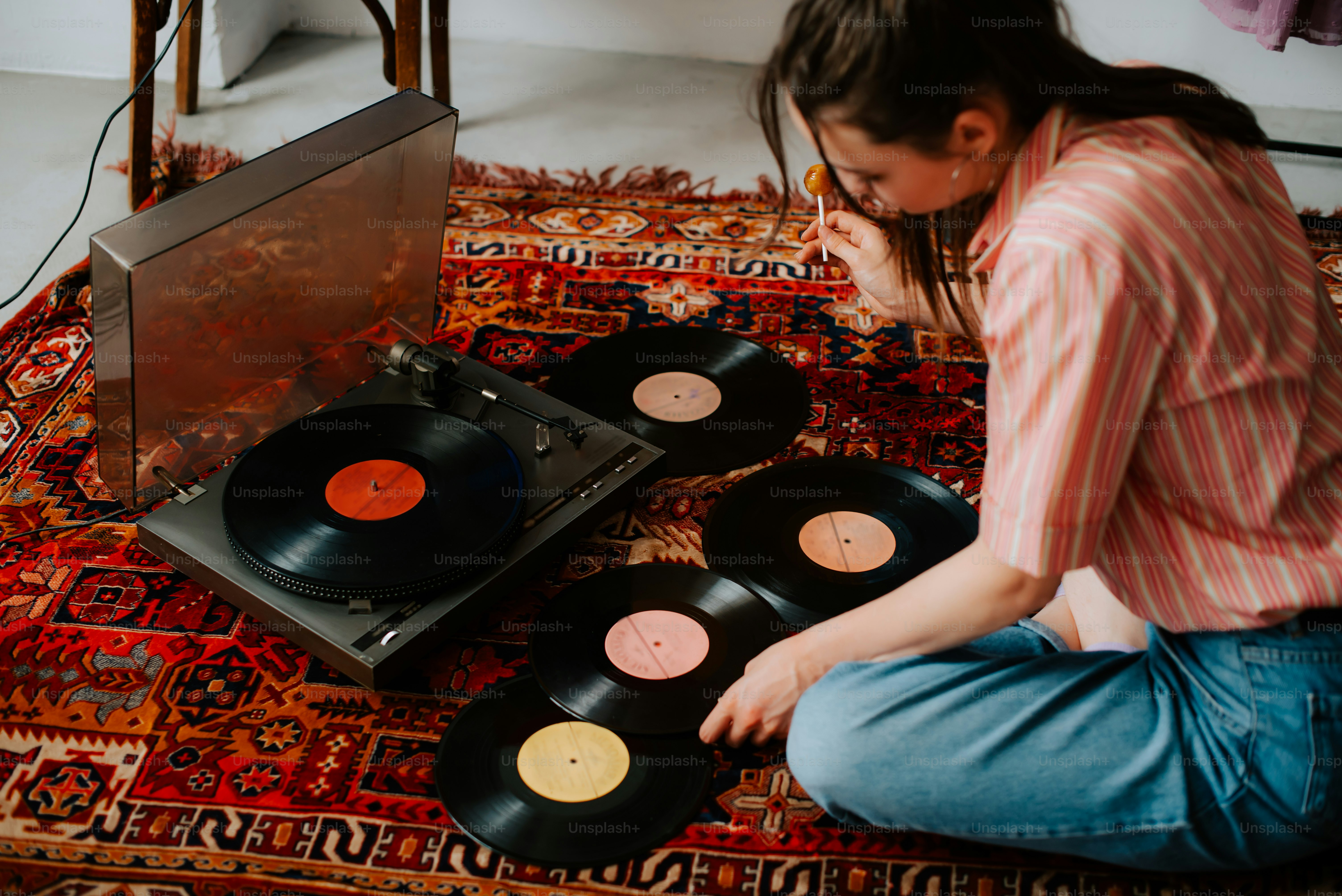 a woman sitting on the floor next to a record player