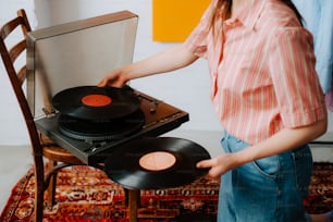 a woman holding a record player in her hands