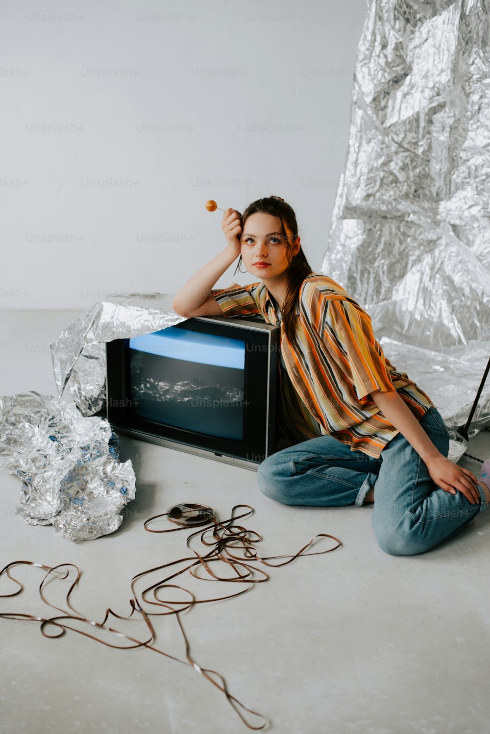 a woman sitting on the floor in front of a tv