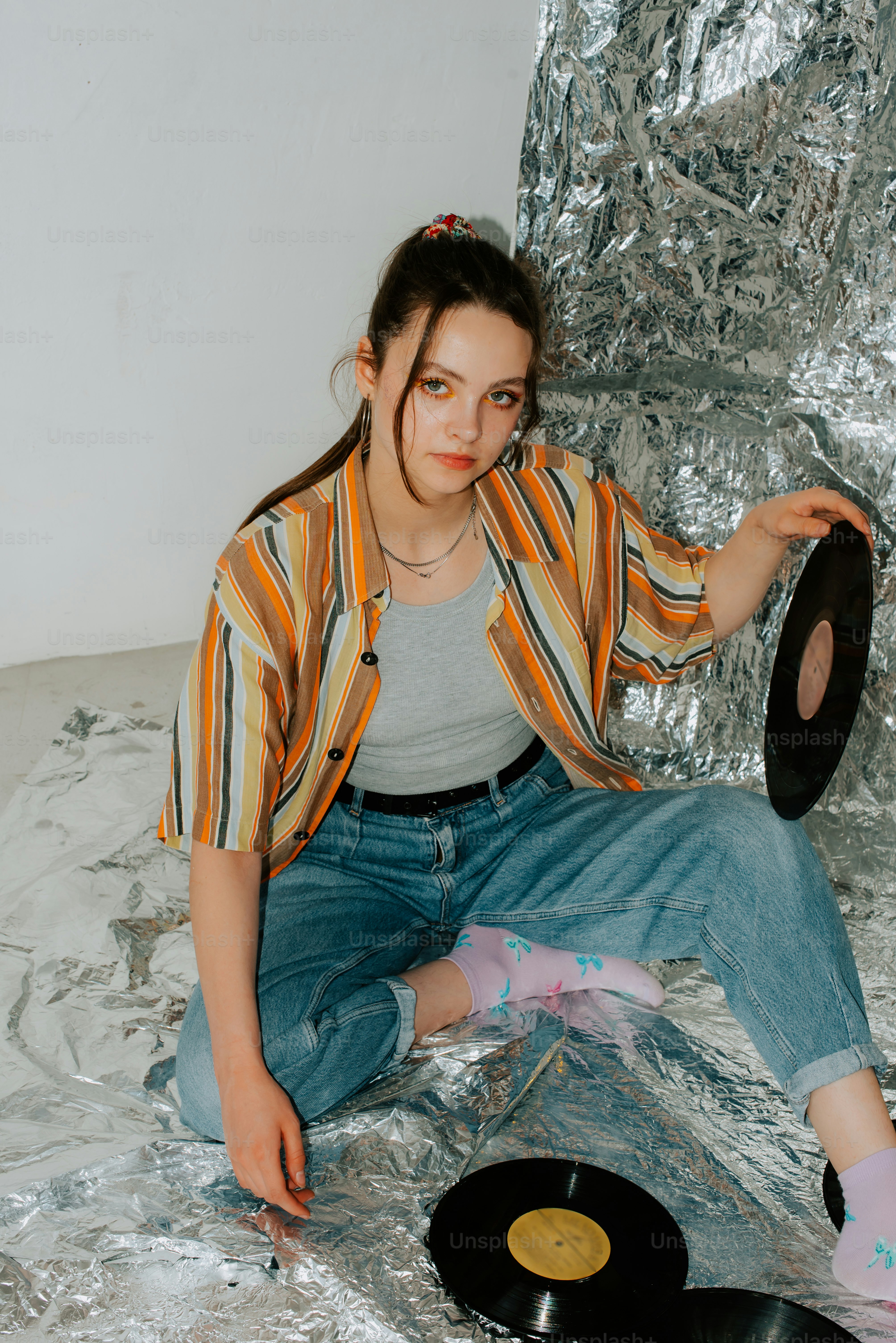 a girl sitting on a bed with a record