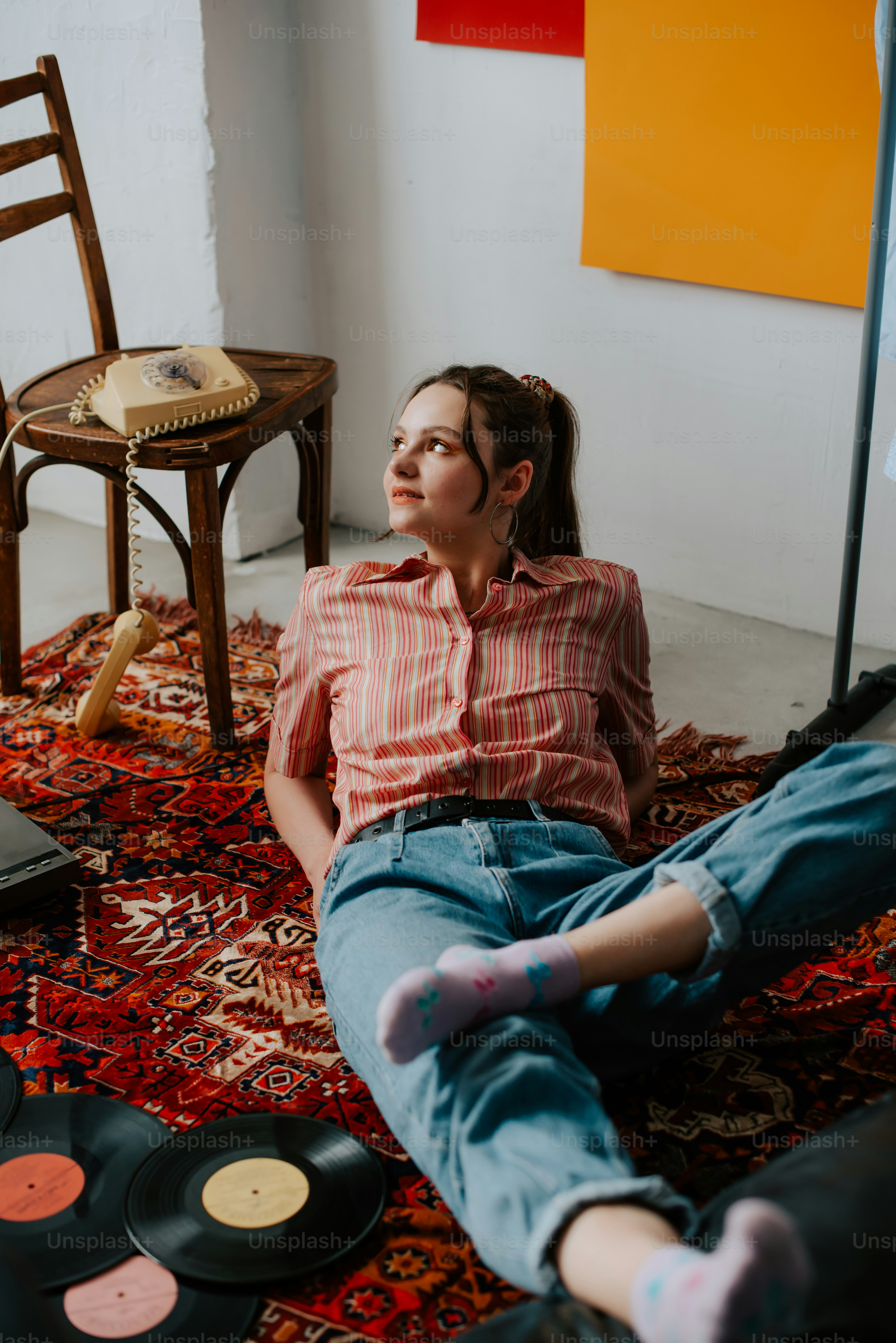a woman sitting on the floor next to a record player