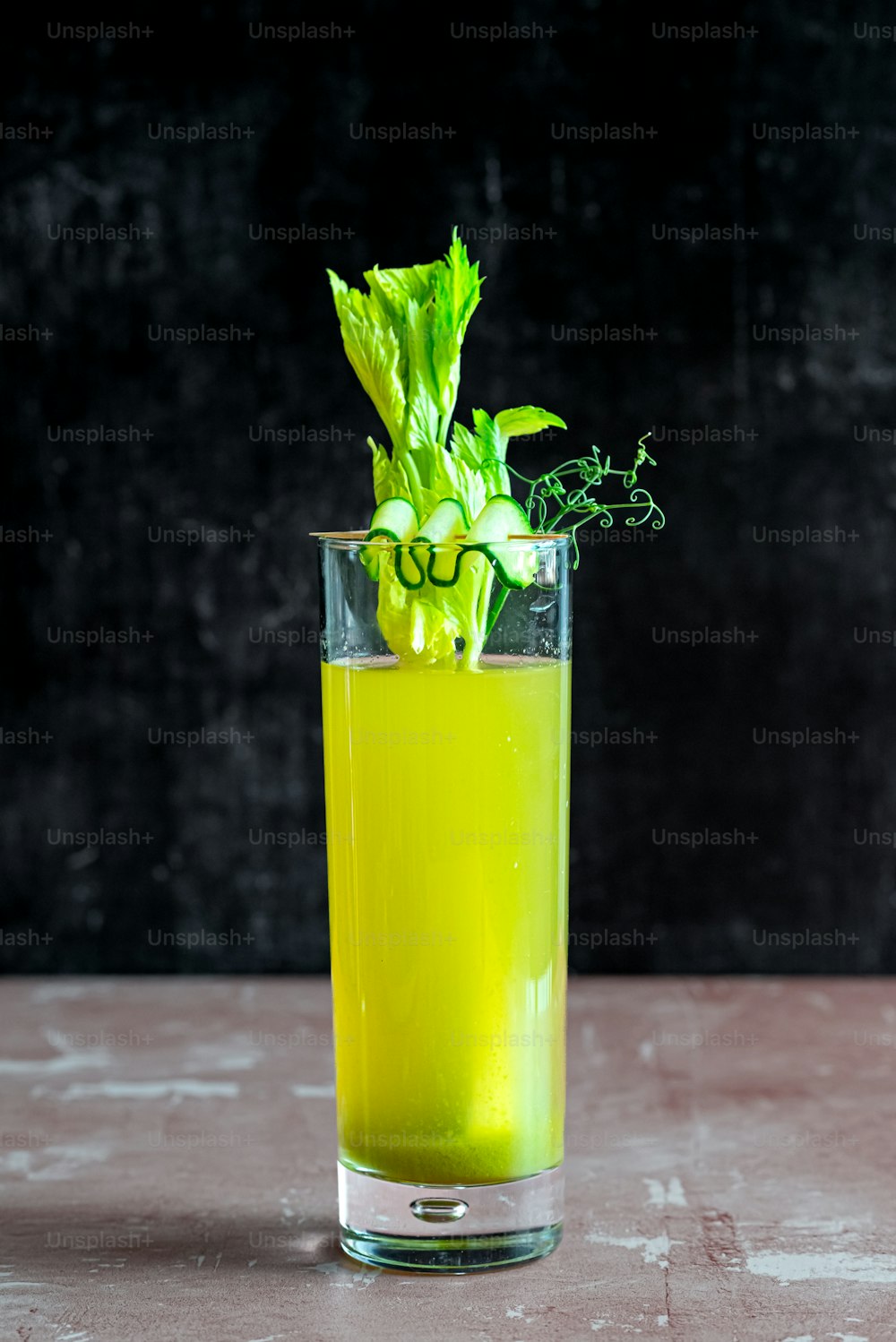 a tall glass filled with a green drink