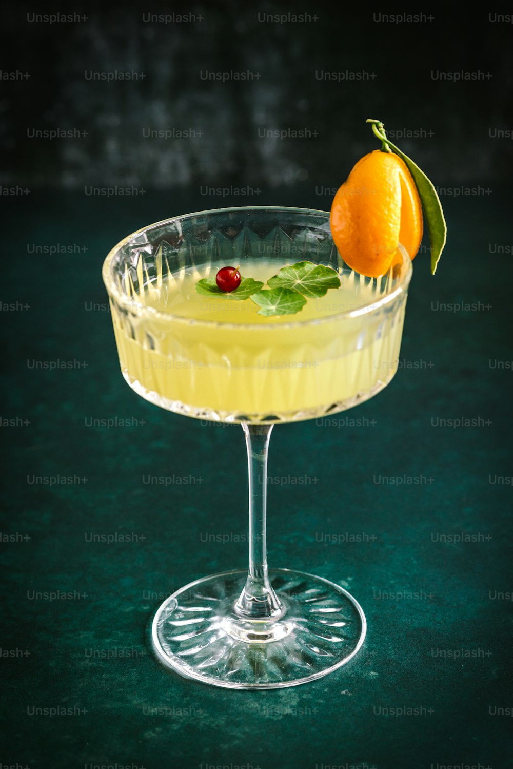 a drink in a glass with an orange garnish