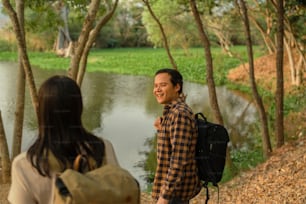 a man with a backpack standing next to a woman