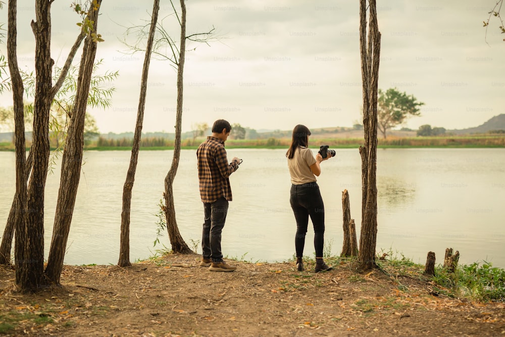 Un homme et une femme debout à côté d’un plan d’eau