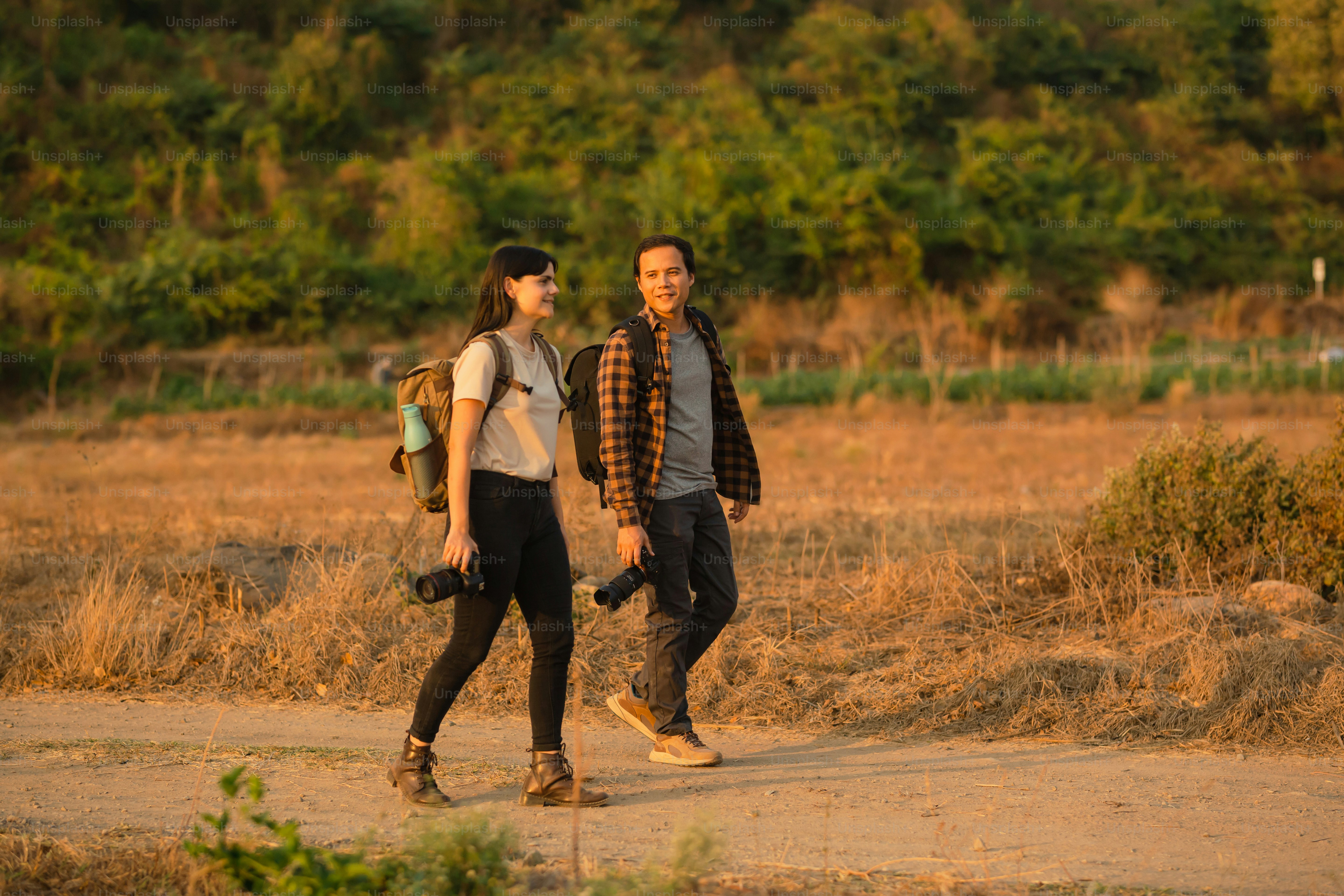a man and a woman walking down a dirt road