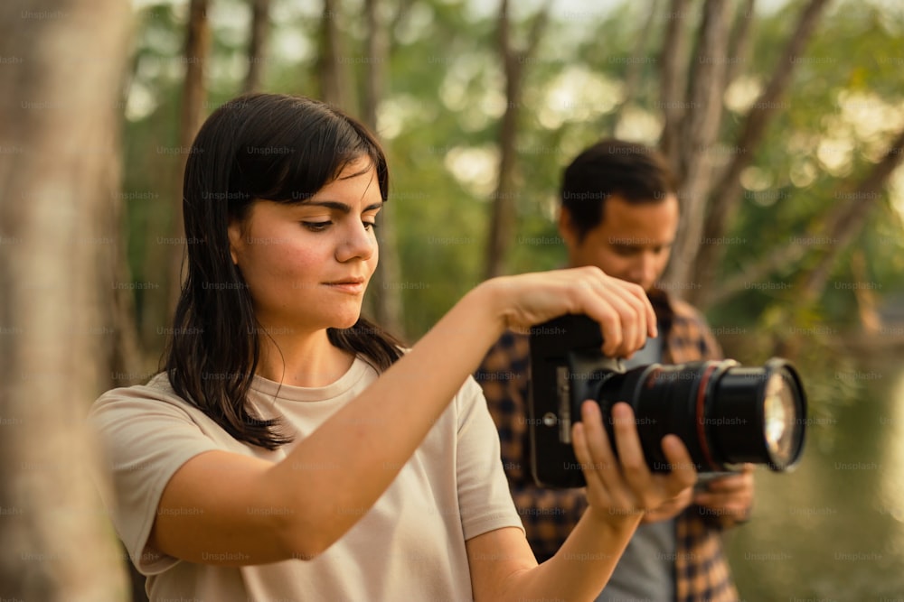 Una mujer sosteniendo una cámara para tomar una foto de un hombre