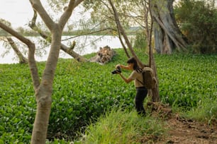 a woman taking a picture of a field with a camera