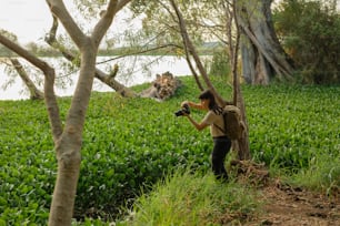 Una mujer tomando una foto de un campo con una cámara