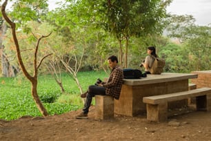 Un par de personas sentadas encima de un banco de cemento