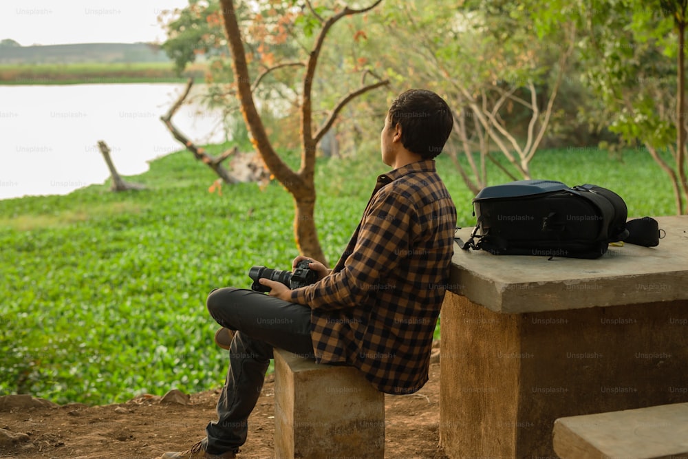 Ein Mann, der auf einer Bank neben einem See sitzt