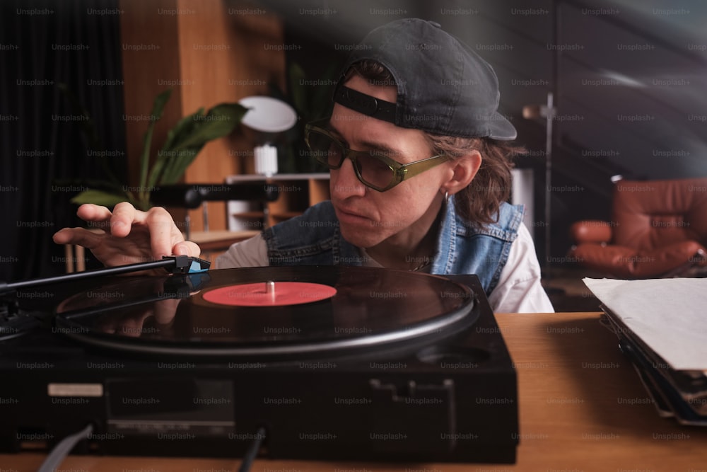帽子と眼鏡をかけた男がレコードを演奏する