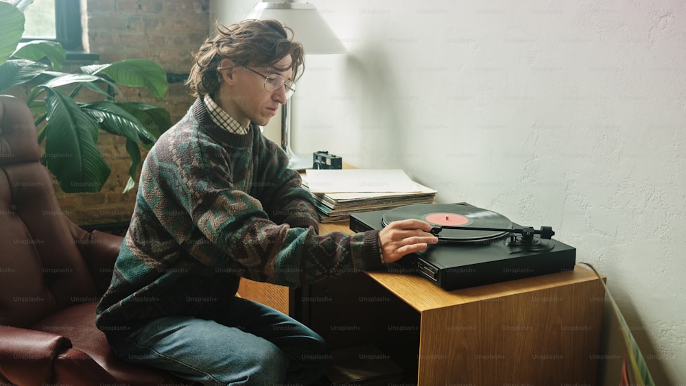une personne assise à un bureau avec un tourne-disque