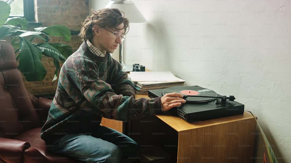 a person sitting at a desk with a record player