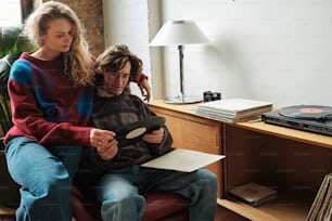 a man and a woman sitting on a couch looking at a tablet