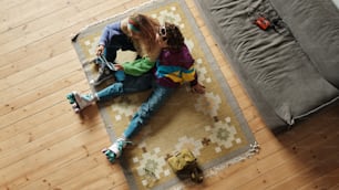 a couple of kids laying on top of a rug