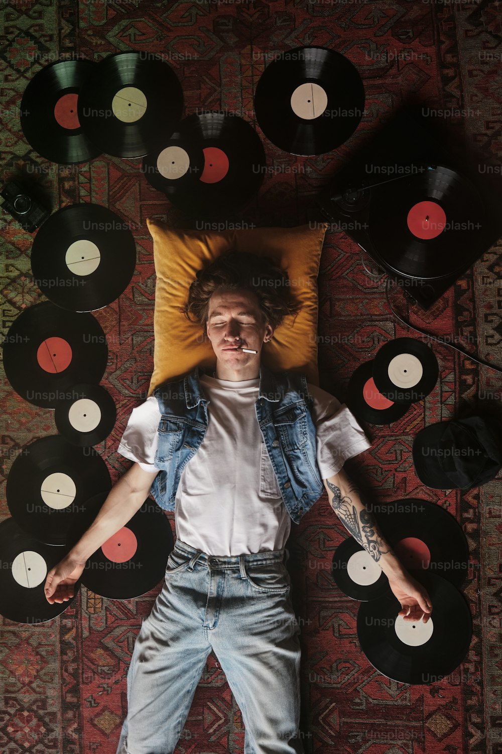 a man laying on top of a pile of records