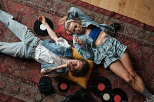 a couple of people laying on top of a rug