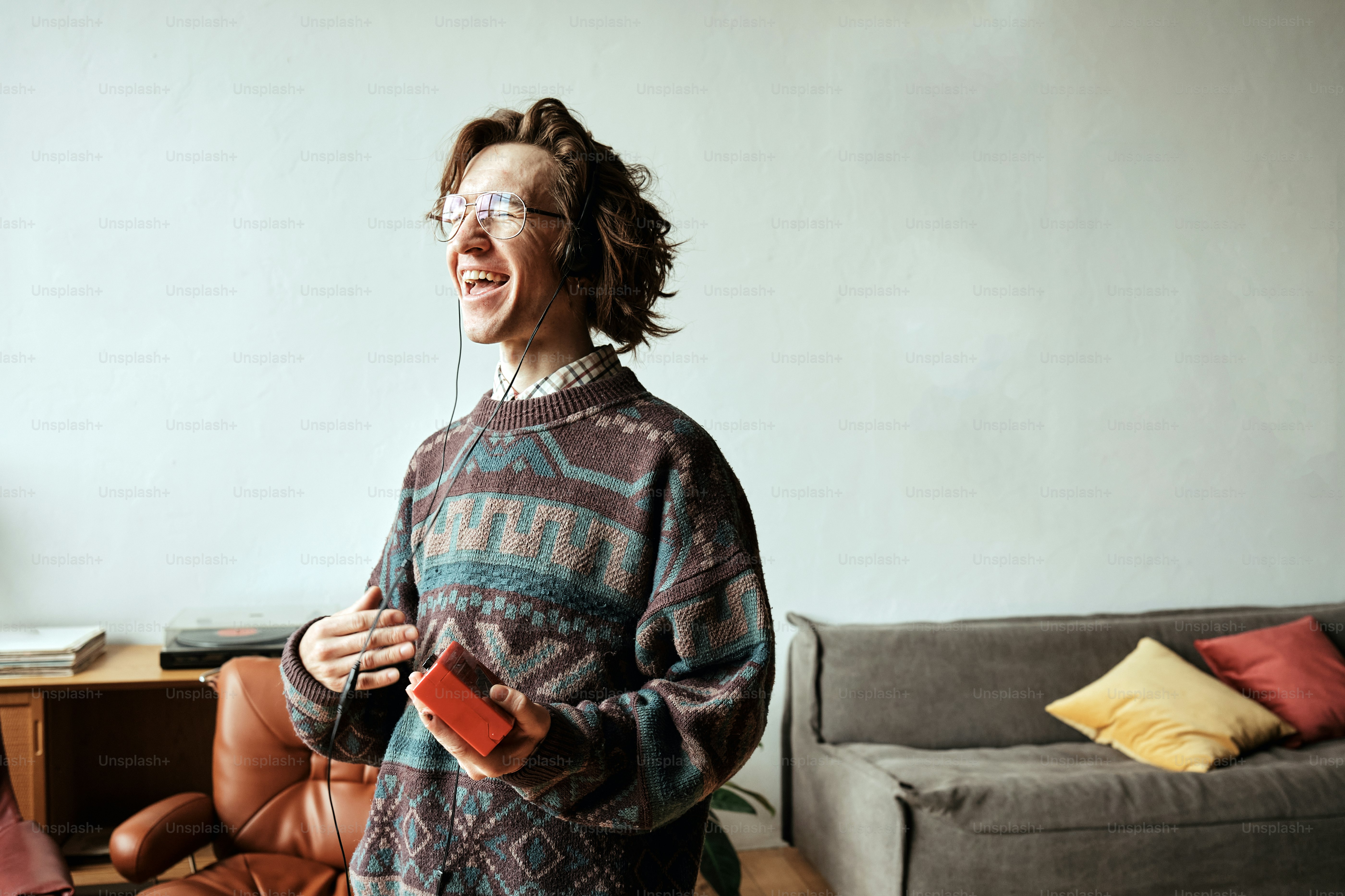 a woman standing in a living room holding a remote