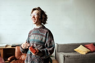 Una mujer parada en una sala de estar sosteniendo un control remoto