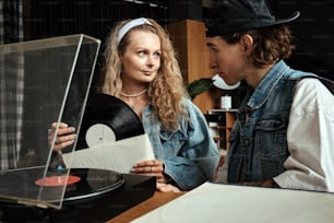 a man and a woman looking at a record player